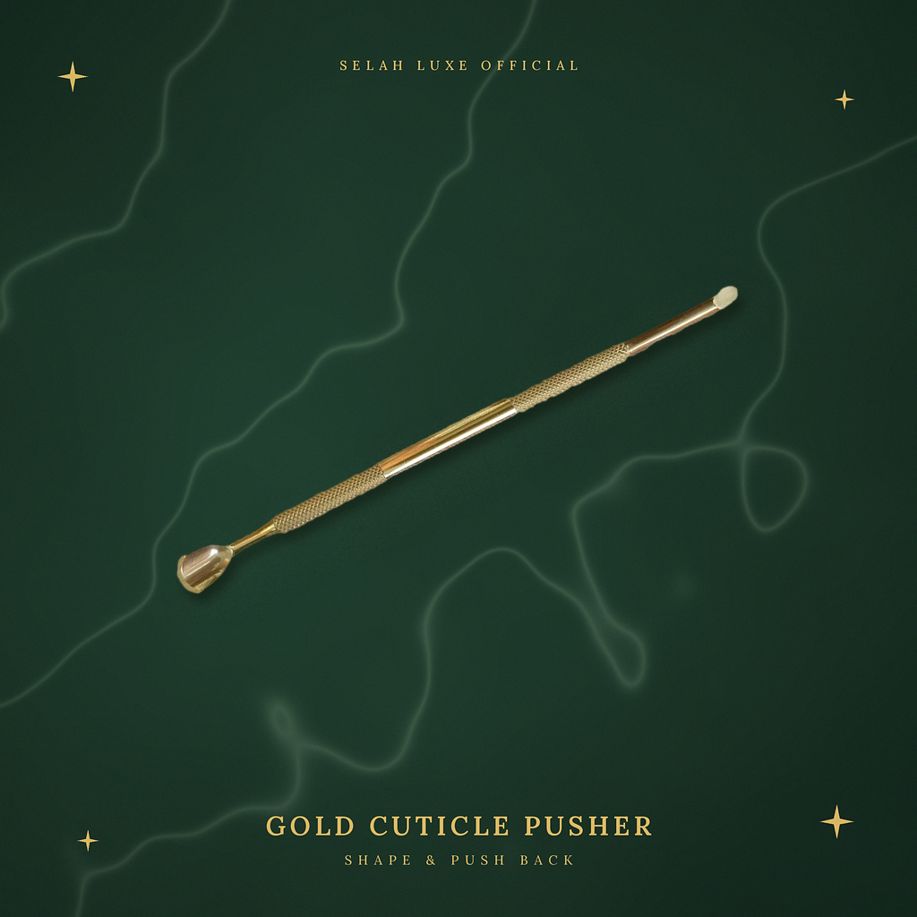 Selah Luxe Official gold cuticle pusher on a cream marble background.