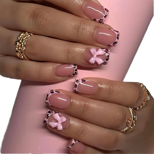 Short square pink press-on nails with leopard print French tips and 3D pink bows on a hand, nail-only refill set.