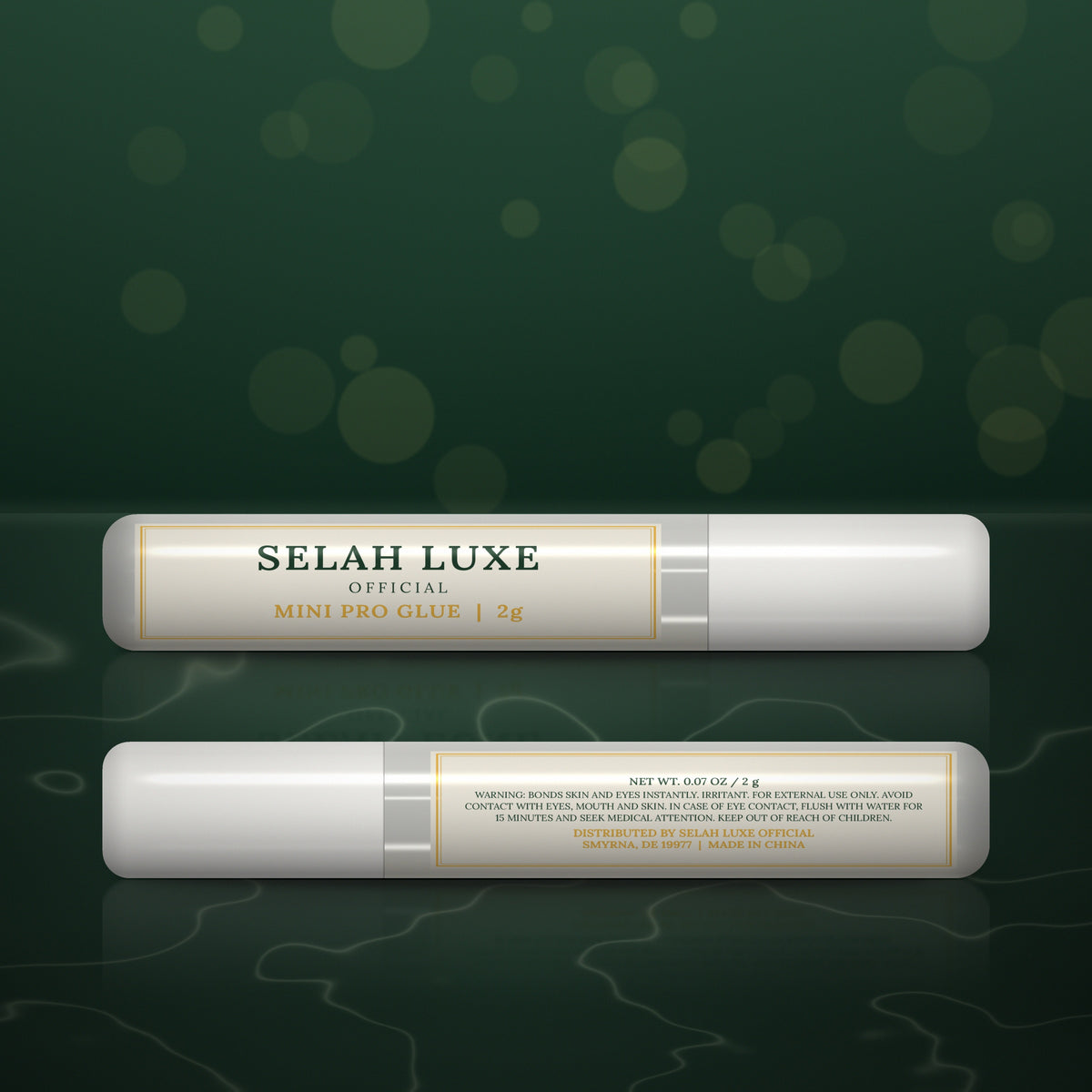 Two tubes of Selah Luxe Official Mini Pro Glue, 2 g, front and back, on a dark green background